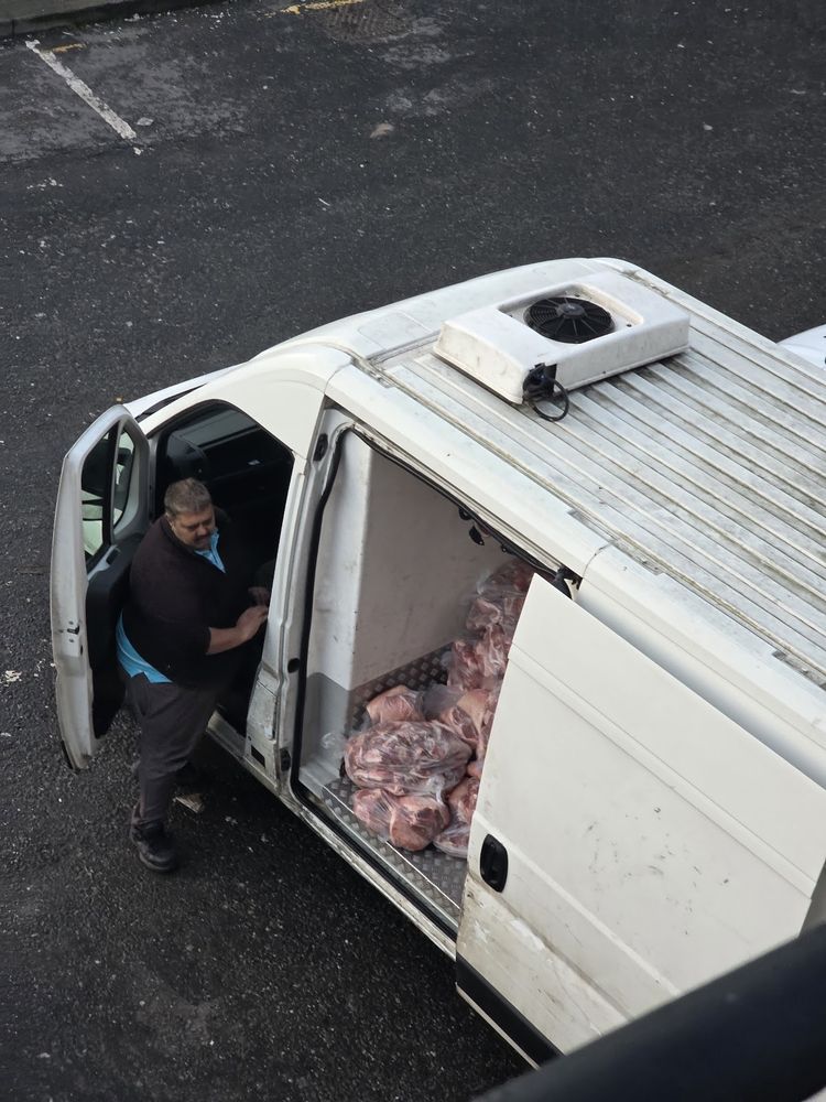 Trays of fresh meat being unloaded from the delivery van at the back of the shop